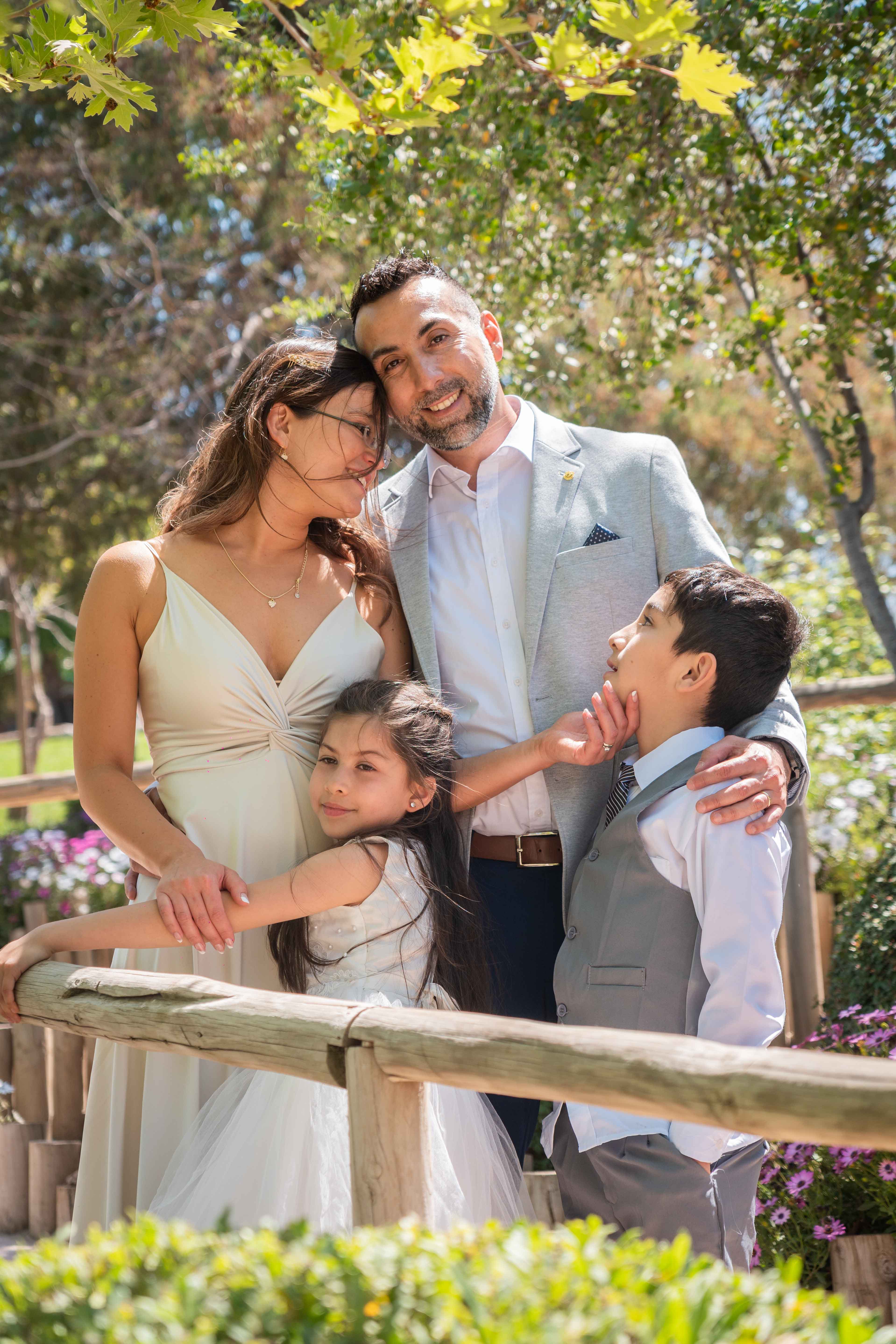 Pareja de recién casados posando con sus hijos pequeños en una tierna escena familiar.