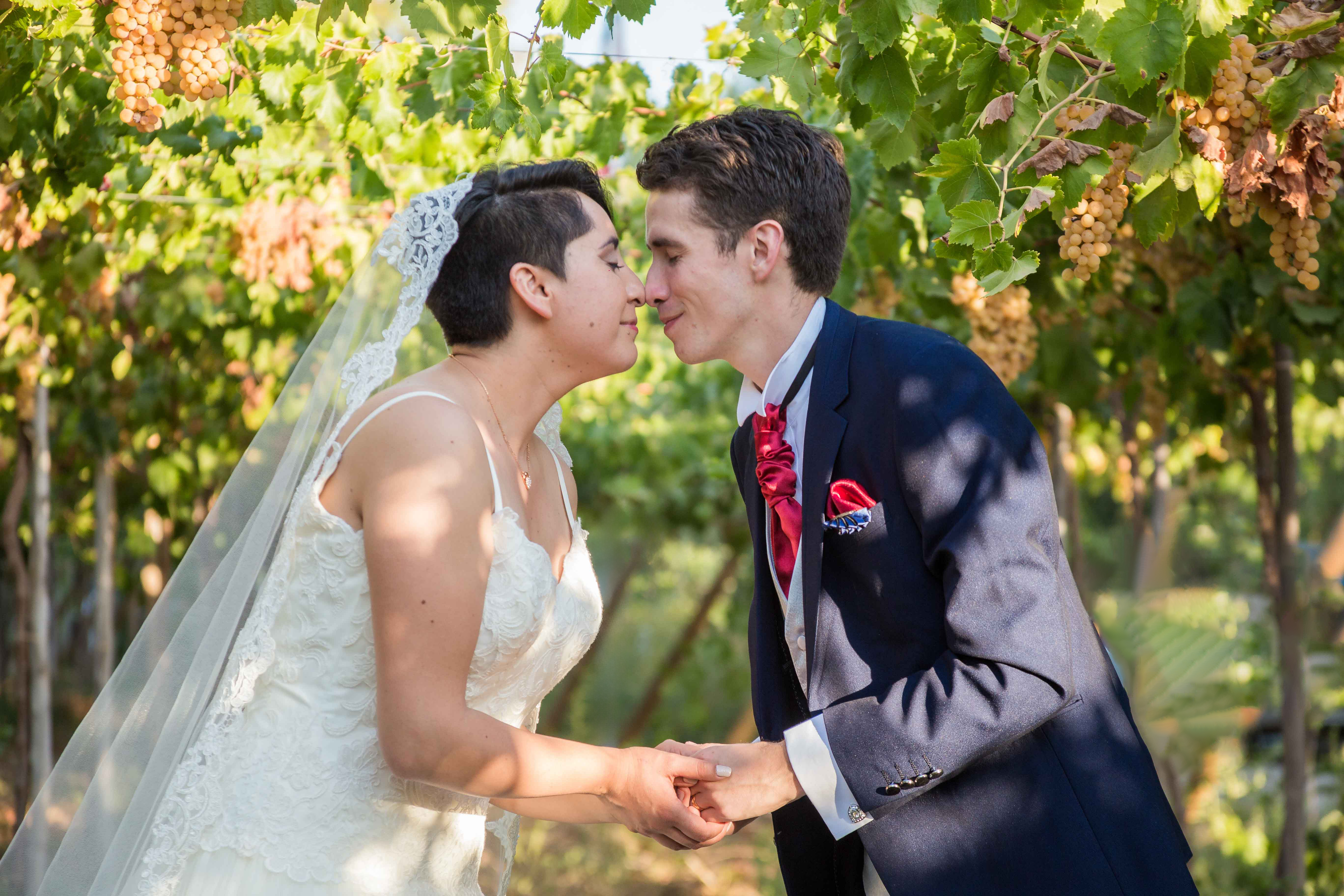 Pareja de jóvenes recién casados posando para una fotografía romántica en una hacienda de campo.