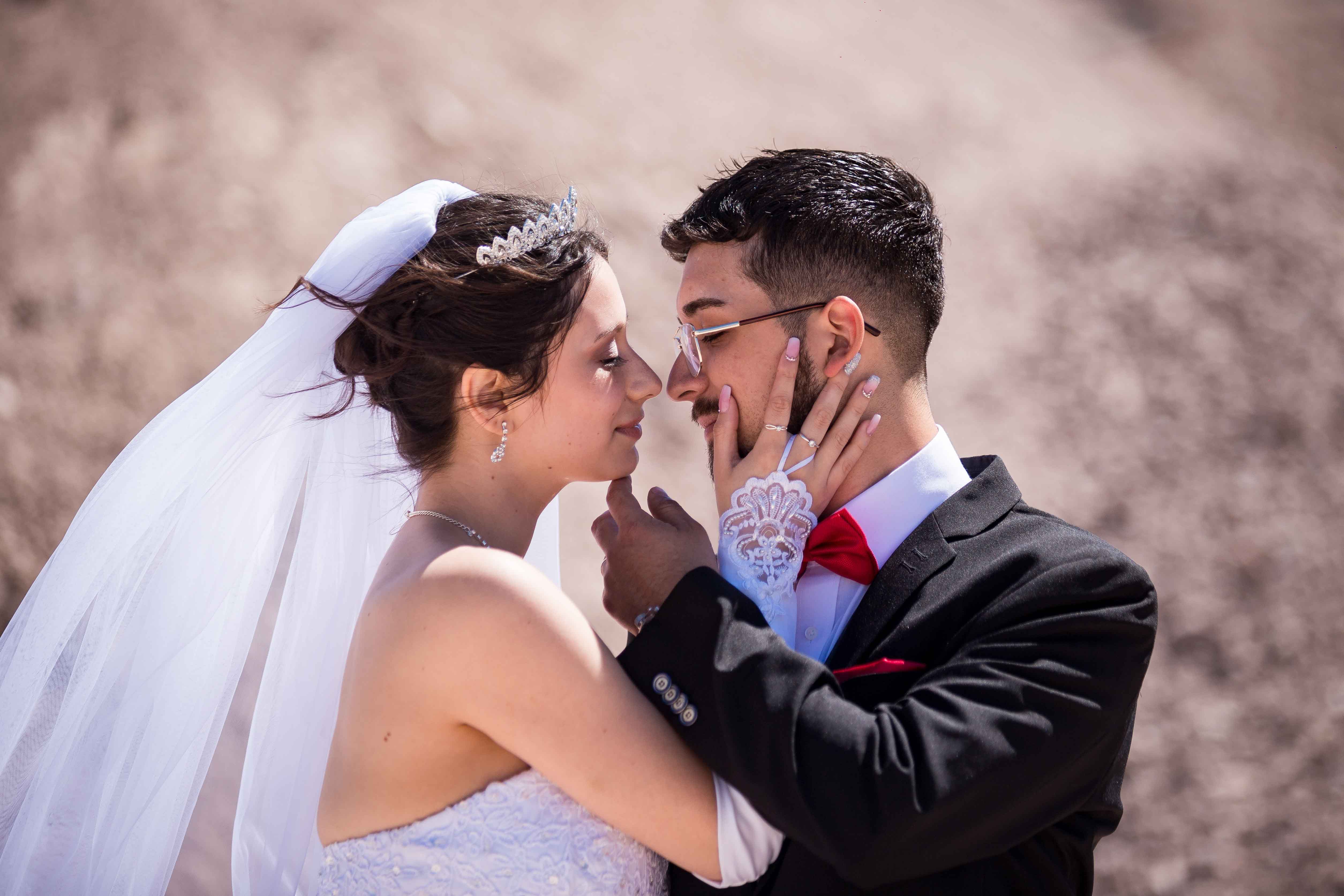 En un entorno pintoresco, la novia y el novio se besan y celebran su amor en medio de imponentes montañas.